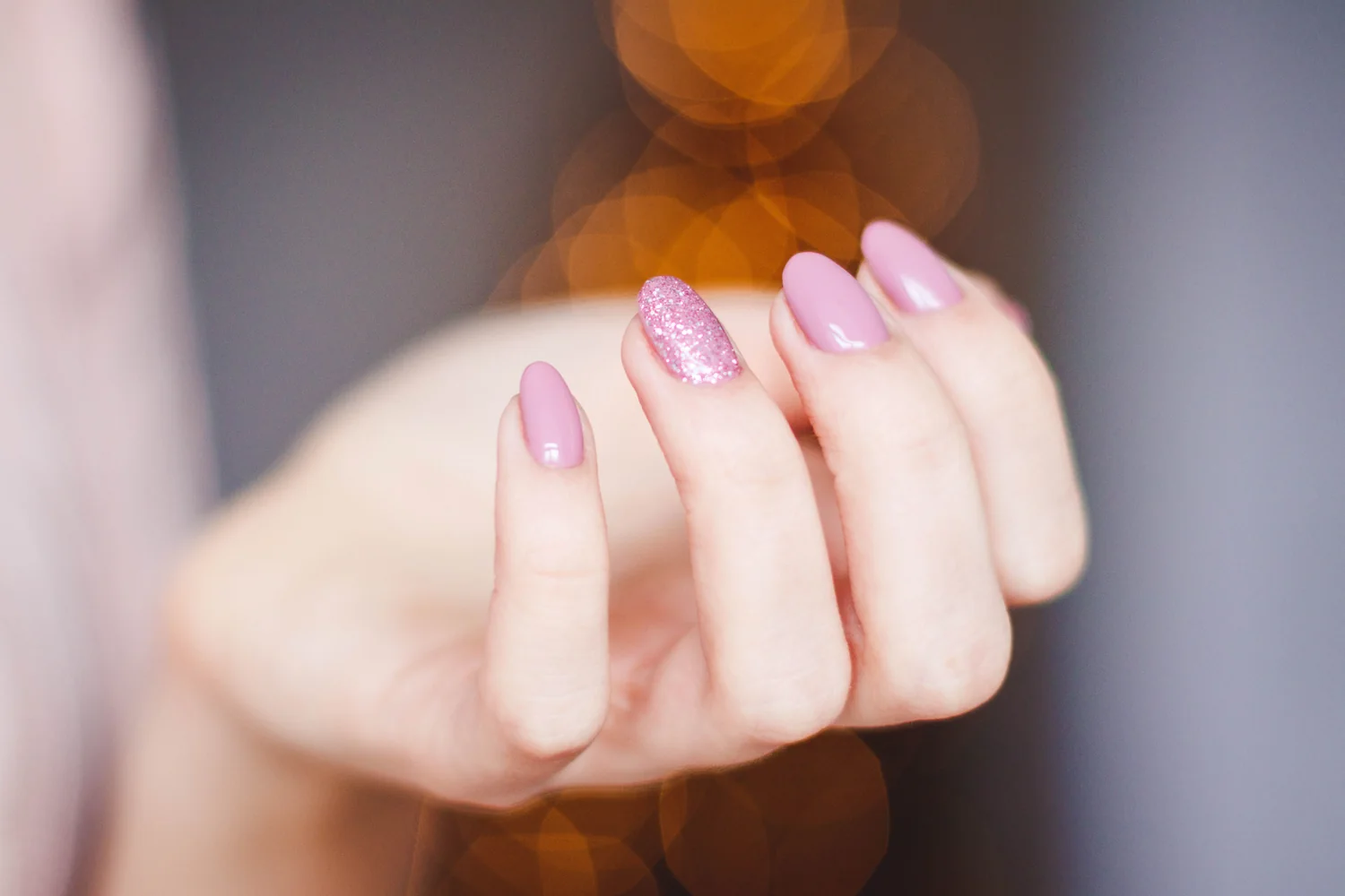Inspiração de unhas naturais rosa com detalhe de glitter